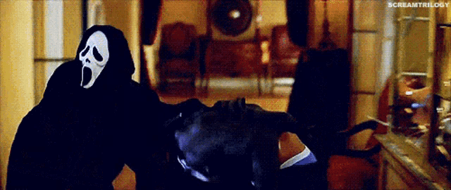 a person in a scream mask is standing next to a person in a black hoodie .