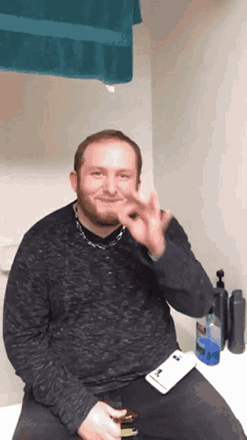 a man with a beard is sitting on a toilet with a toothbrush and a toothpaste