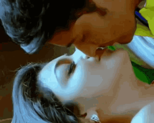 a man and a woman are kissing in a close up of their faces