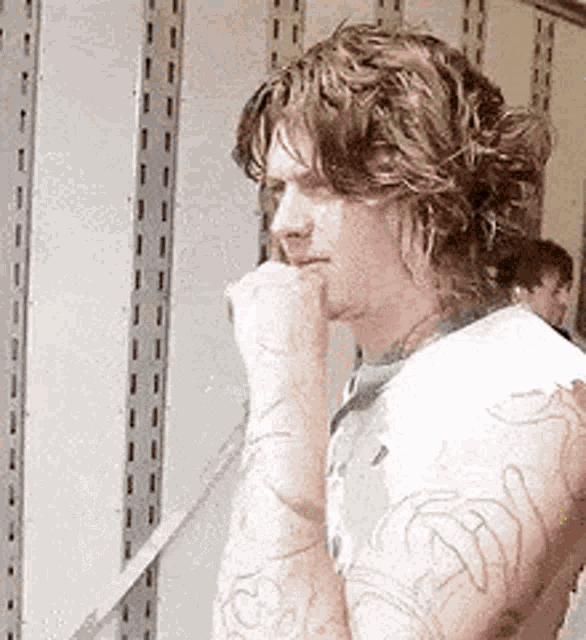 a man with a tattoo on his arm is looking down