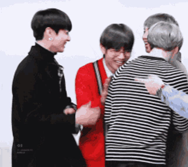 a group of men are standing next to each other and laughing .