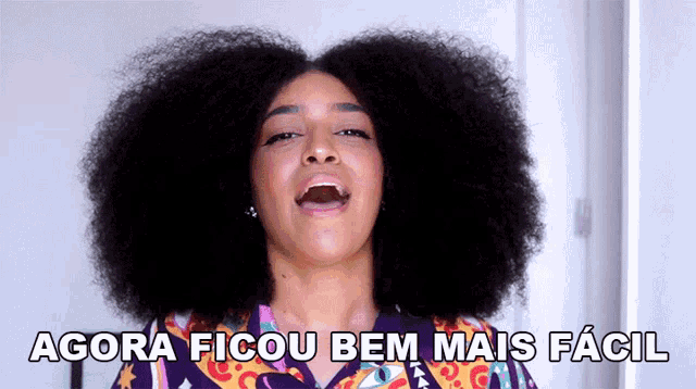 a woman with curly hair says agora ficou bem mais facil in a foreign language