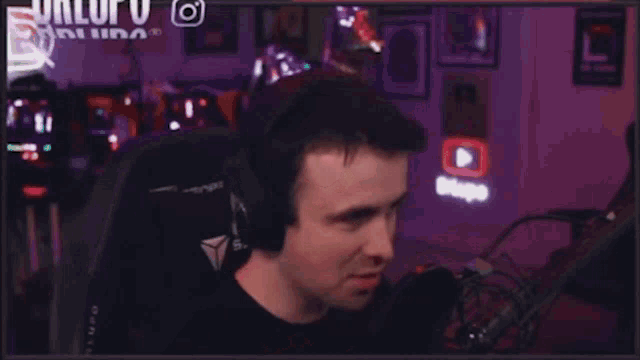 a man wearing headphones is sitting in a chair with his fist in the air .