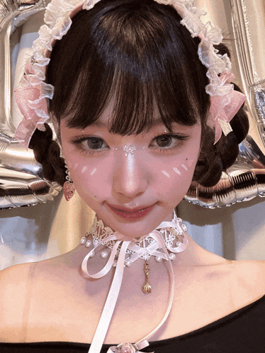 a girl wearing a pink and white headband and a choker with pearls