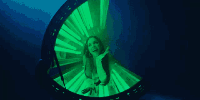 a woman is standing in a green lighted room
