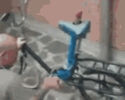 a man is fixing a bicycle with a blue seat
