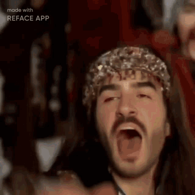 a man with long hair and a beard is wearing a headband and a scarf .