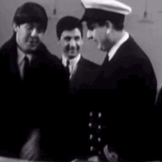 two men in suits and hats are standing next to each other .