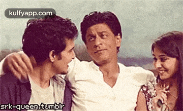 a man and two women are sitting next to each other and hugging .