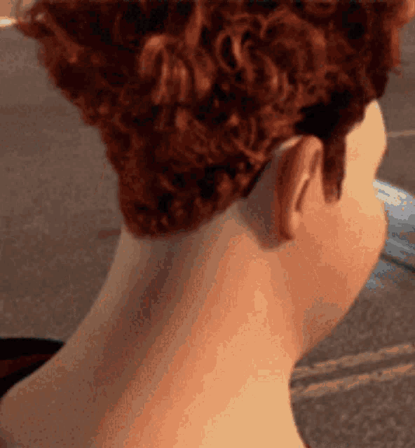 a woman with red curly hair has a shaved head