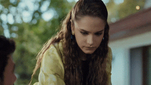 a woman in a yellow jacket looks down at something