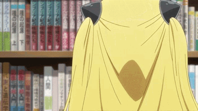 a woman in a yellow cape is standing in front of a bookshelf .