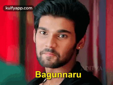 a man with a beard and earrings is looking at the camera with the word bagunnaru written on his face .