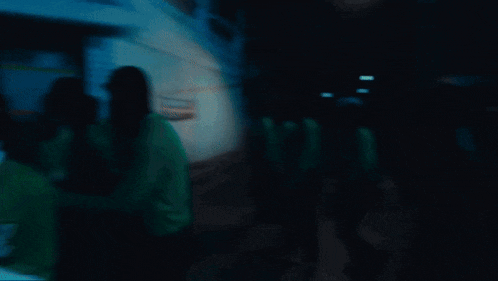 a blurry picture of a man wearing a green sweatshirt that says ' eek ' on it