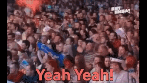 a crowd of people sitting in a stadium with the words yeah yeah written on the screen .