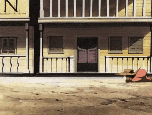 a man in a cowboy hat is laying in front of a building with the letter n on it