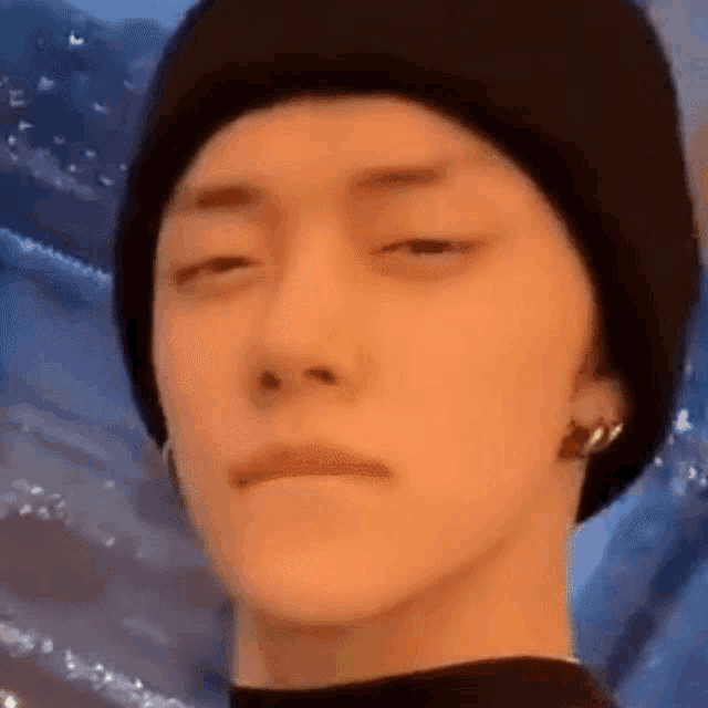 a close up of a man wearing a black beanie and making a funny face .
