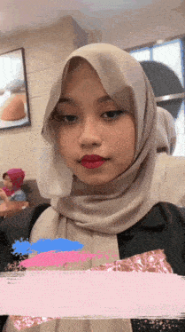 a woman wearing a hijab and red lipstick