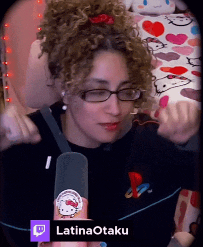 a woman with curly hair is wearing glasses and a hello kitty sticker on her sweater