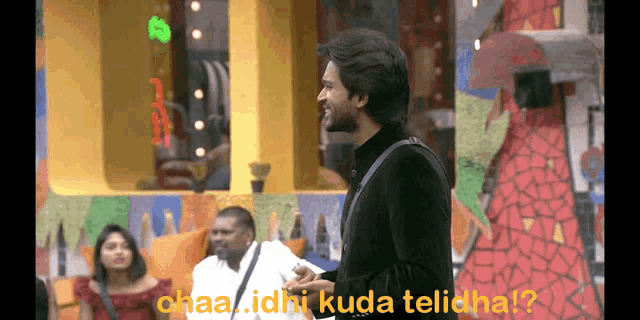 a man stands in front of a sign that says chaa / idhi kuda telidha