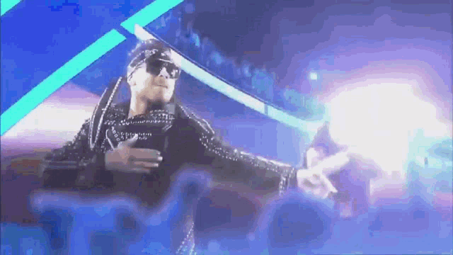 a man wearing sunglasses and a bandana is standing in front of a crowd .