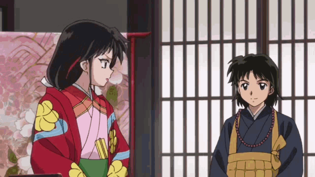a couple of anime characters standing next to each other in front of a window