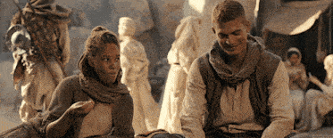 a man and a woman are sitting next to each other in a crowded area