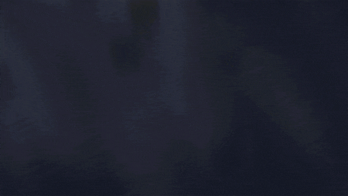 a silhouette of a dragon with wings is flying in the dark