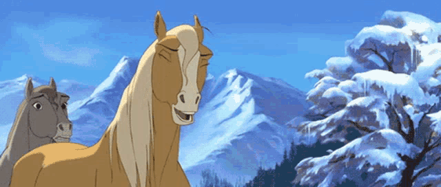 two horses standing in front of snowy mountains