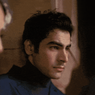 a close up of a man 's face with a turtleneck