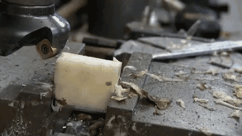 a machine is cutting a piece of soap on a metal surface .