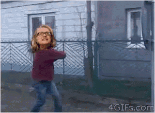 a girl with glasses is dancing in front of a house with a 4gifs.com logo on the bottom
