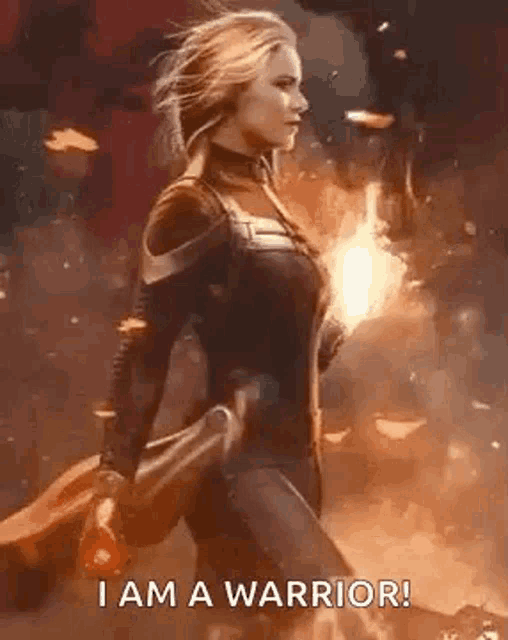 a woman in a superhero costume is holding a fire and says `` i am a warrior '' .
