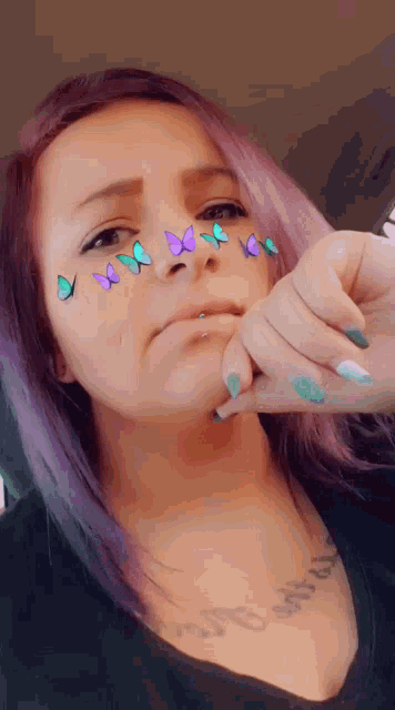 a woman with purple hair and butterflies on her face is making a funny face