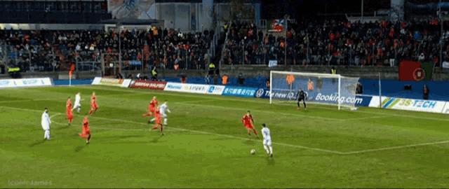 a soccer game is being played in a stadium with a banner for booking.com
