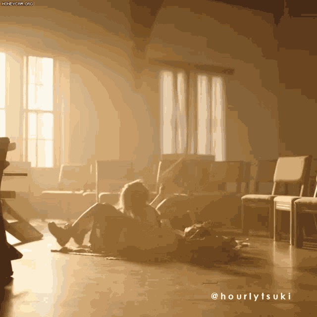 a woman is laying on the floor in a room with the name hourlytsuki written on the bottom