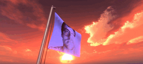 a flag with a picture of a man on it is flying in the wind