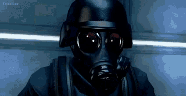 a soldier wearing a gas mask and helmet is standing in a dark room .