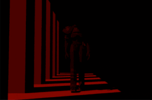 a silhouette of a man holding a sword in a dark room