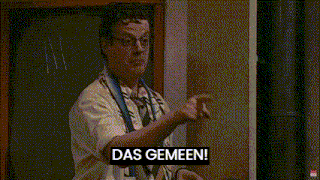 a man wearing a scarf that says das gemeen stands next to another man