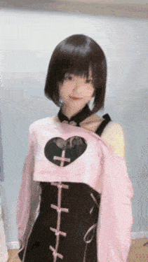 the girl is wearing a pink dress with a heart on the front .
