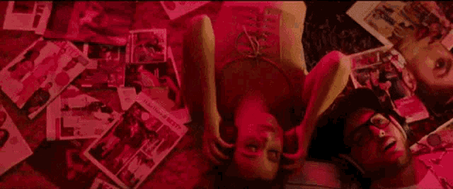 a man and a woman are laying on top of each other on a bed surrounded by magazines .