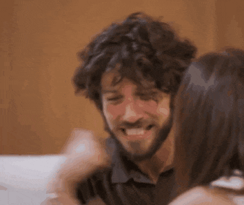 a man with a beard is hugging a woman with long hair .