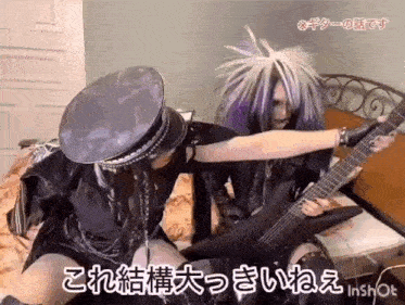 two people are sitting on a bed playing guitars .