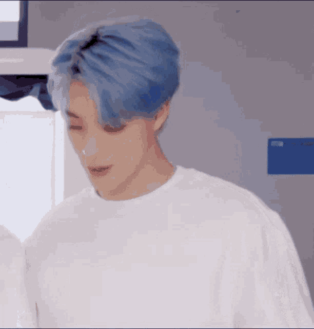a young man with blue hair is wearing a white t-shirt and red lipstick .