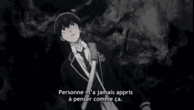 a boy in a suit and tie is standing in a dark room with a backpack .