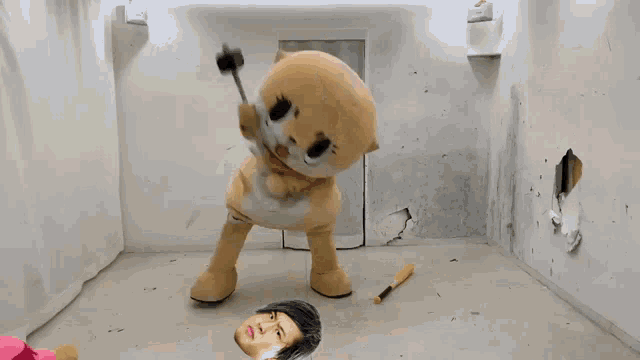 a stuffed animal mascot is holding a hammer in front of a hole in the wall
