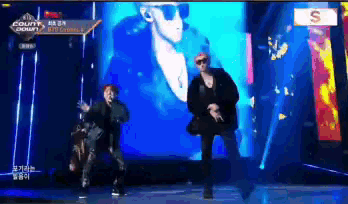 two men are dancing on a stage in front of a sign that says ' count ' on it