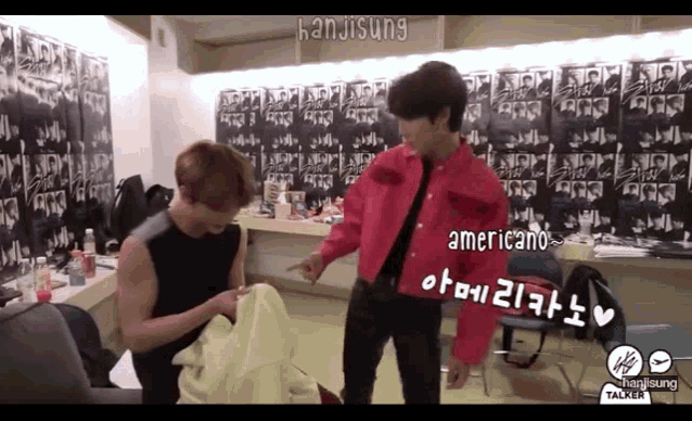 a man in a red shirt is standing next to another man in a black shirt ..