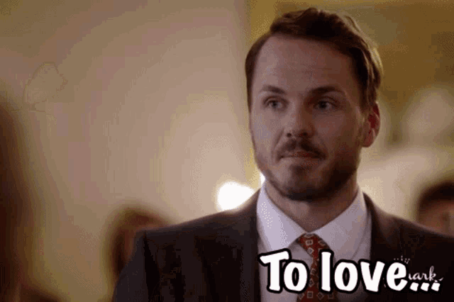 a man in a suit and tie with the words to love written on the bottom
